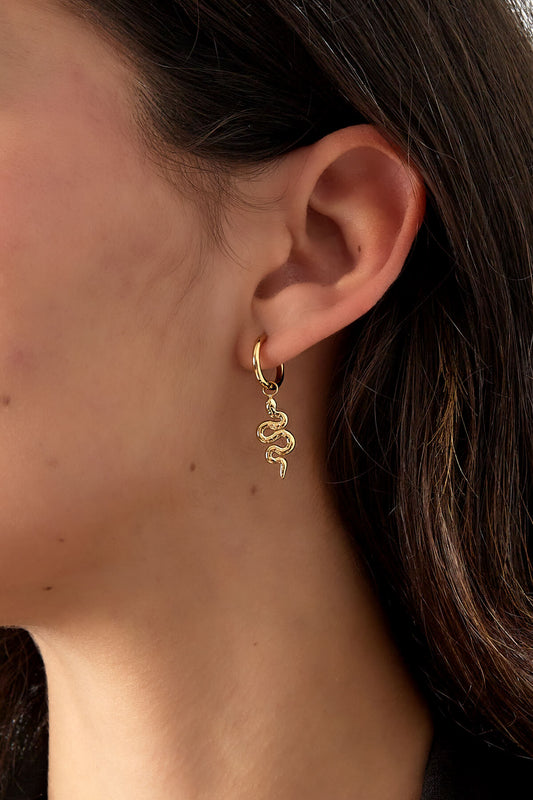 Vrouw draagt trendy oorbellen met slang in de kleur goud. Gemaakt van stainless steel.