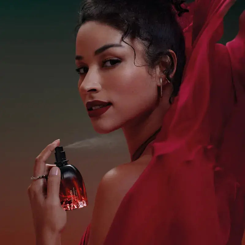 Vrouwelijke model die Floratta Red Passion sprayt. Sensueel en elegant.