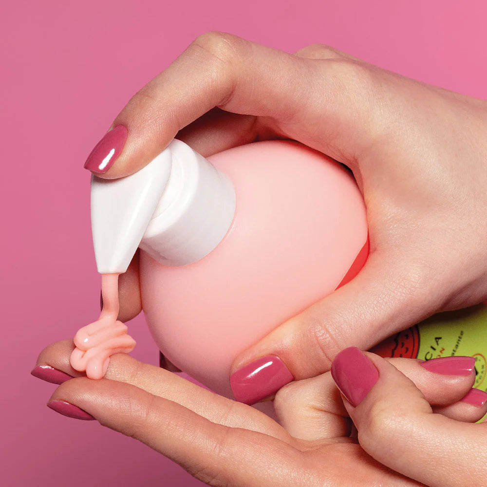 Hand pompt Cuide-se Bem Melancia bodylotion van O Boticário op vingers – romige hydraterende crème met frisse watermeloengeur.