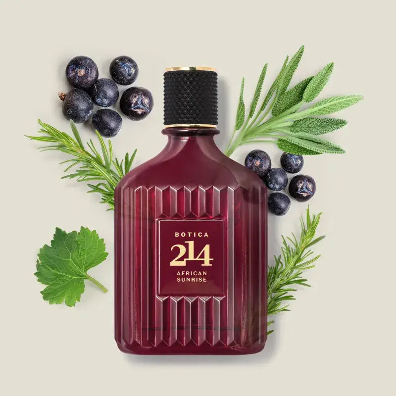 Flacon van Botica 214 African Sunrise Eau de Parfum 90 ml voor mannen, omringd door jeneverbessen, rozemarijn, salie en groene bladeren – ingrediënten van de geur