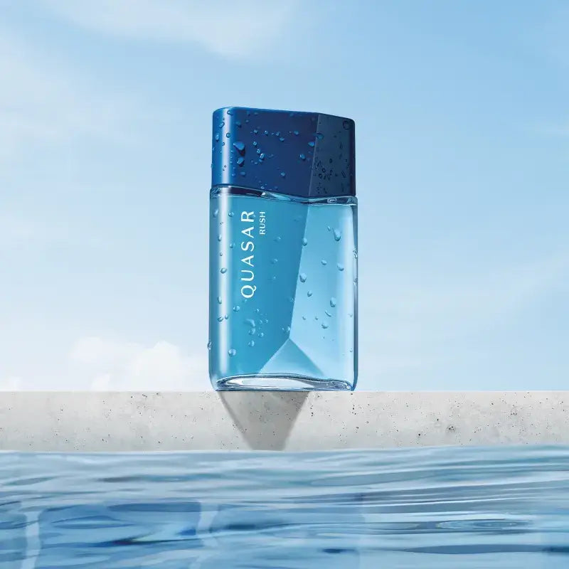 Productfoto van Quasar Rush Eau de Toilette op een achtergrond met waterdruppels – frisse fougère-geur.