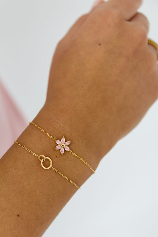 Dames armband van stainless steel met een roze strass bloem bedel, gedragen om de pols