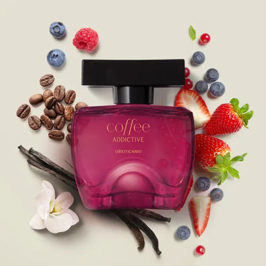 Close-up van het parfumflesje met koffiebonen, cacaobonen en rode vruchten op de achtergrond