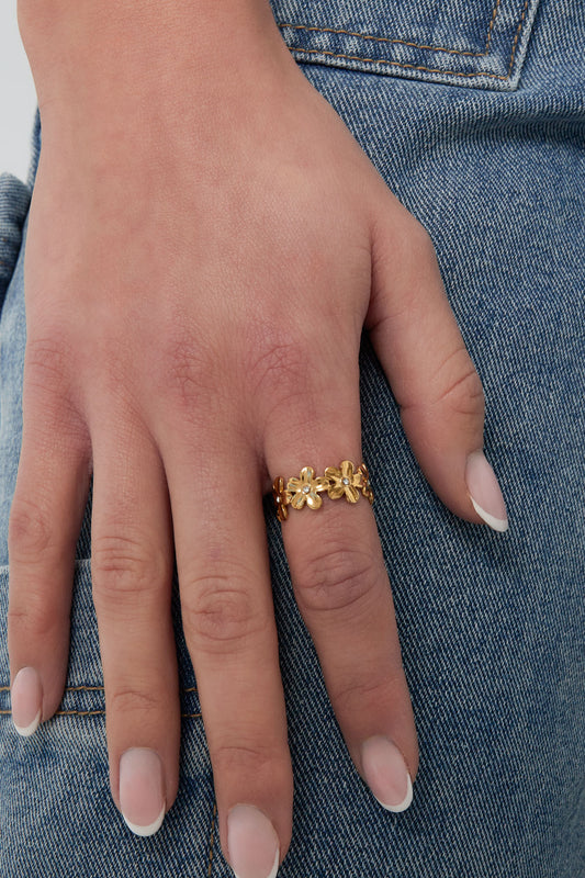 Verstelbare stainless steel ring met bloemen in de kleur goud. Gedragen door een model om haar wijsvinger