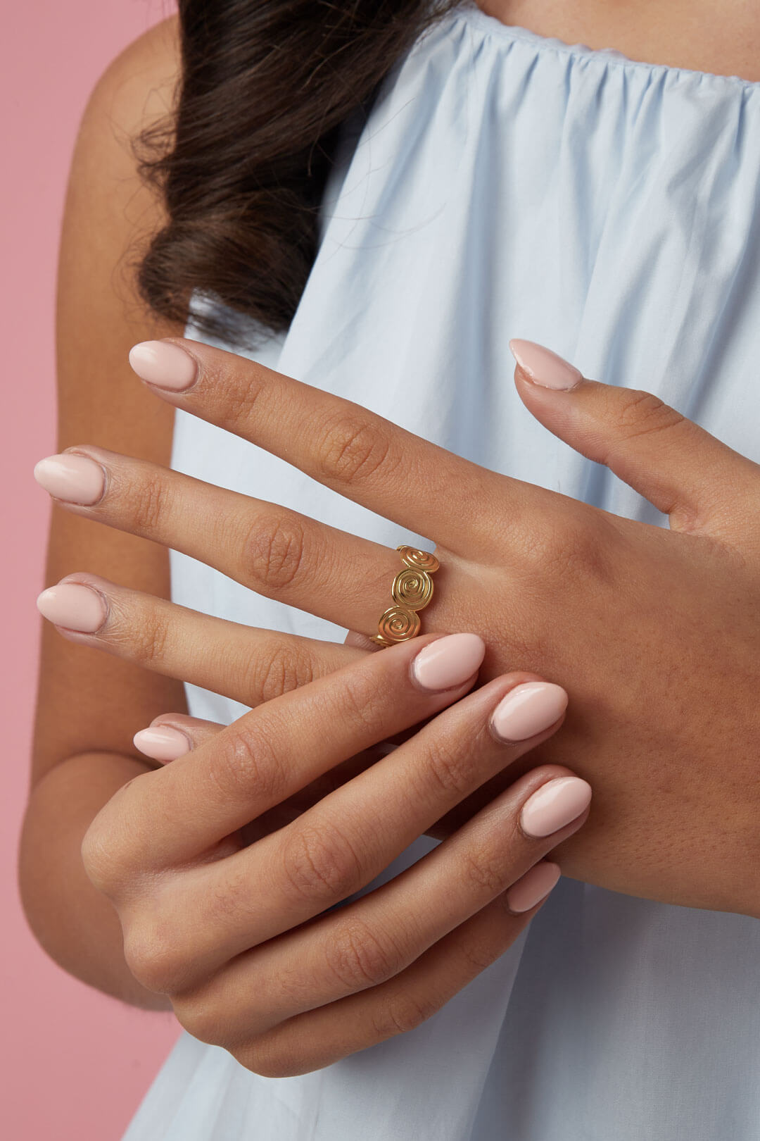 Verstelbare ring met een twisted vorm in de kleur goud, gedragen om middelvinger