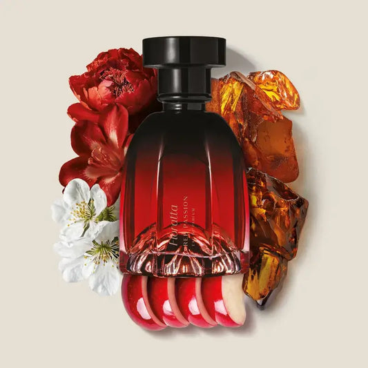 Rode parfumfles Floratta Red Passion omringd door bloemen, amber en appel