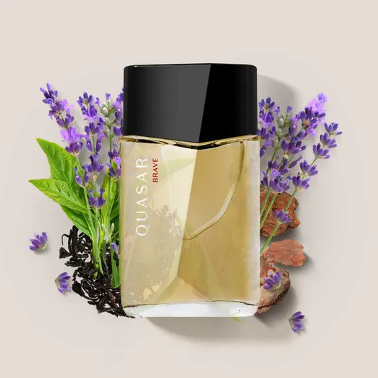Flacon van Quasar Brave Eau de Toilette omringd door lavendel, theebladeren en hout – symbool van frisse, aromatische mannelijkheid