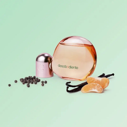 Flesje van Desobediente Eau de Parfum 100ml met ingrediënten zoals zwarte peper, mandarijn en vanille op een mintgroene achtergrond.